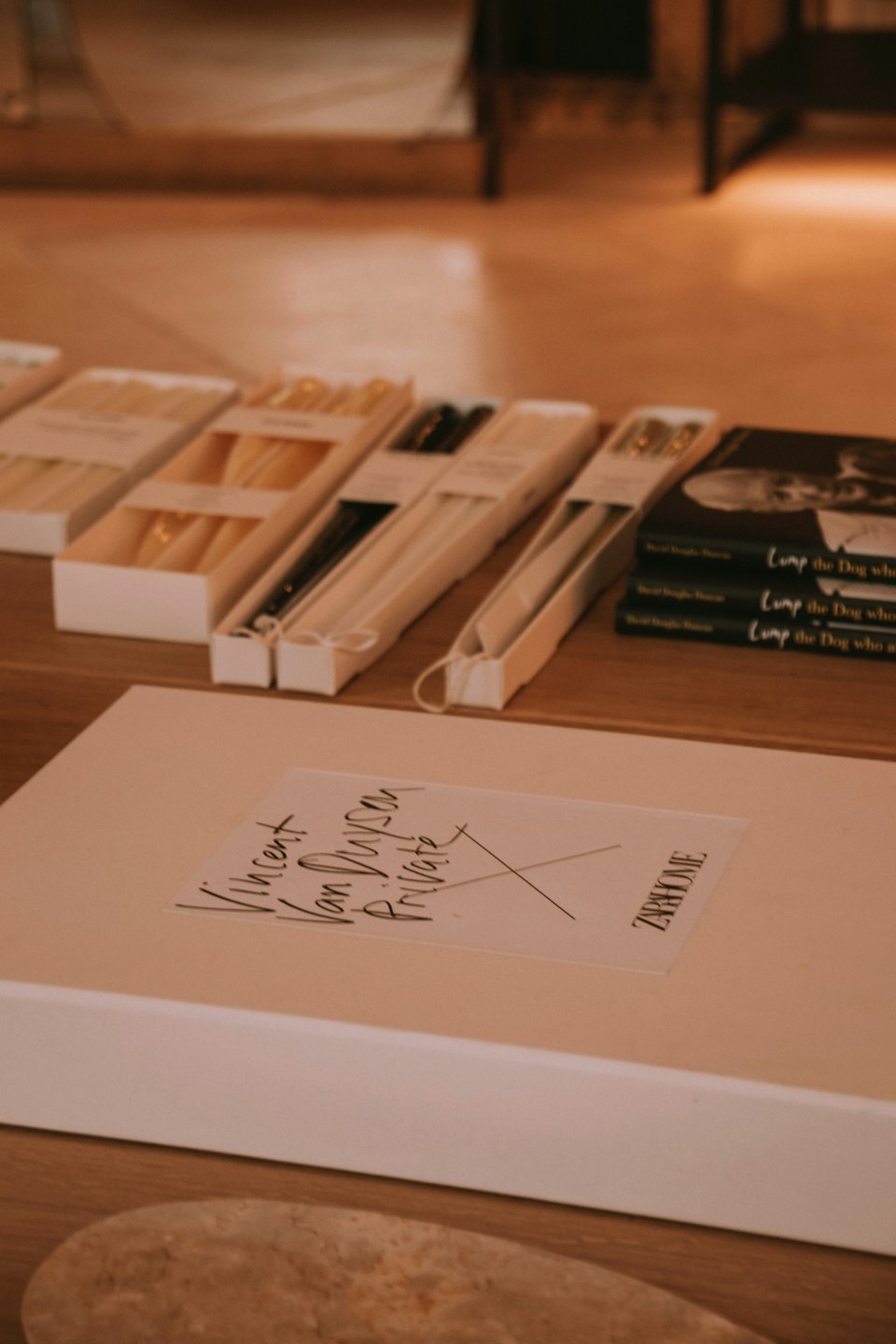 Scatole da negozio e libri impilati disposti su un tavolo di legno.