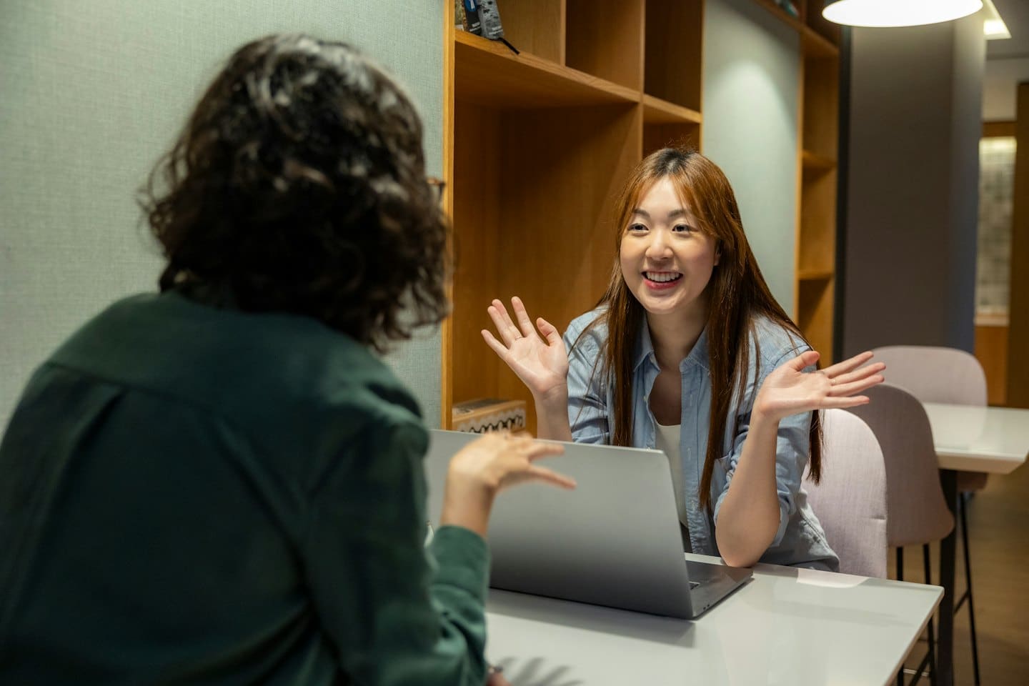 Donna discute di affari con una collega a un laptop.